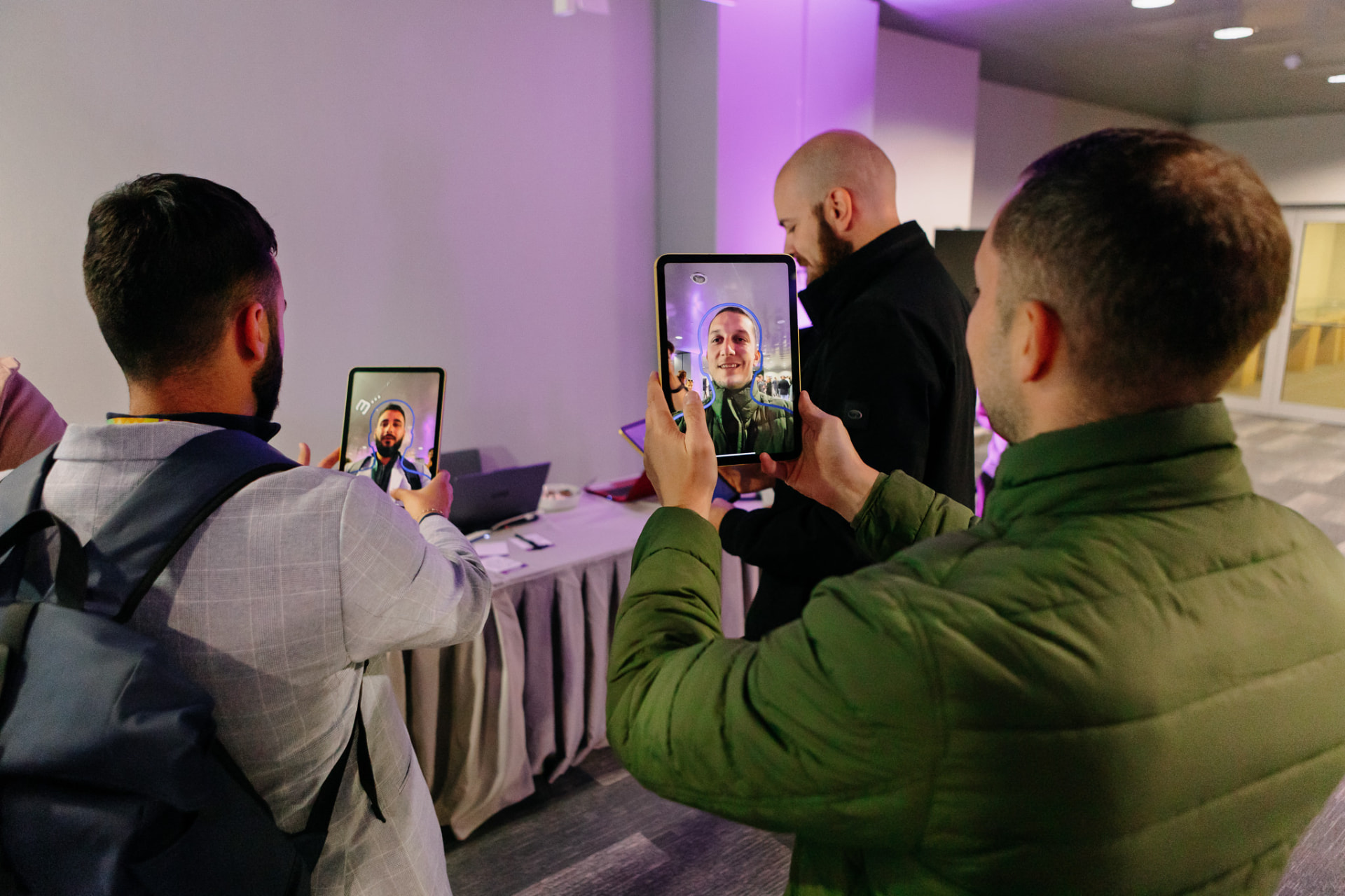Two conference guests photographing themselves on tablets at the SketchBot station
